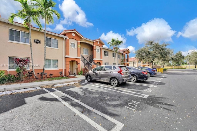 3505 Briar Bay Blvd Unit 104, West Palm Beach, FL 33411 - uncovered parking lot featuring a residential view and stairs