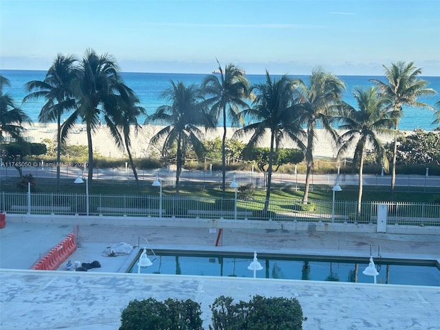 view of home's community with a water view, fence, and a pool