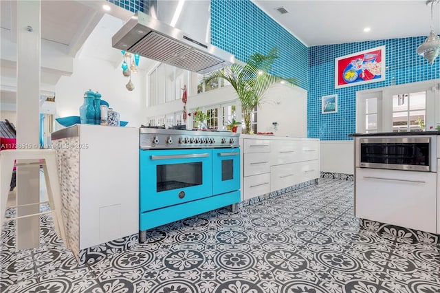 kitchen with visible vents, appliances with stainless steel finishes, and range hood