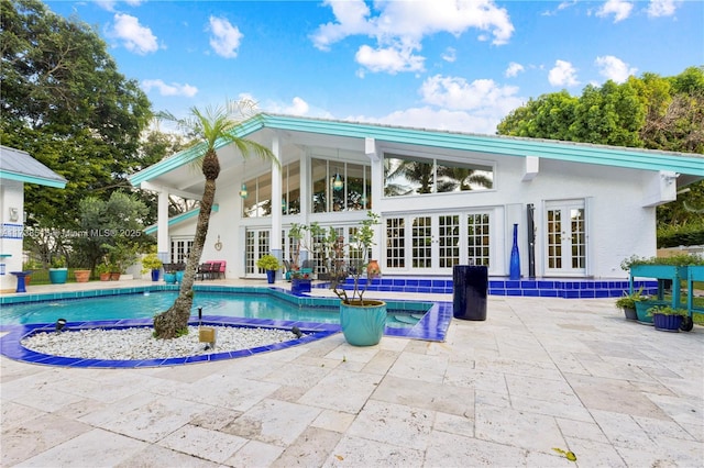 outdoor pool with a patio and french doors