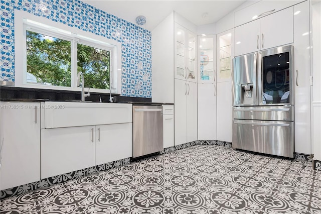 kitchen with white cabinetry, wallpapered walls, appliances with stainless steel finishes, and dark countertops