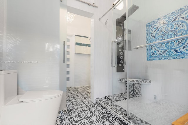 full bath featuring tile patterned floors, a tile shower, and toilet
