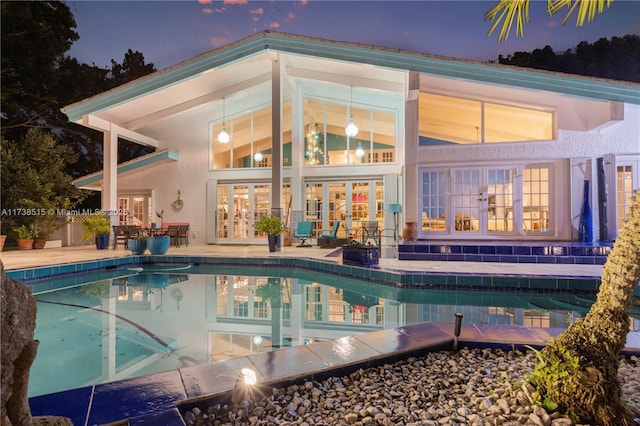 outdoor pool with french doors and a patio
