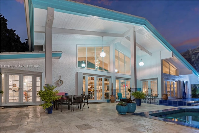 rear view of property featuring a patio, french doors, and stucco siding