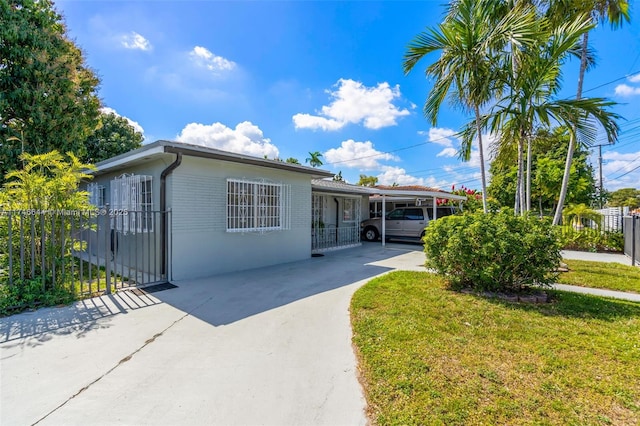 view of front of property featuring a front lawn and a carport