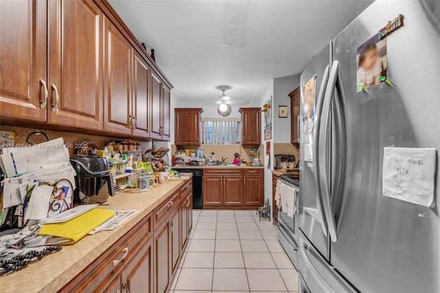 kitchen with stainless steel appliances, ceiling fan, and light tile patterned flooring