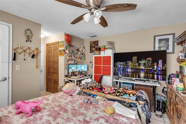 tiled bedroom featuring ceiling fan and a closet