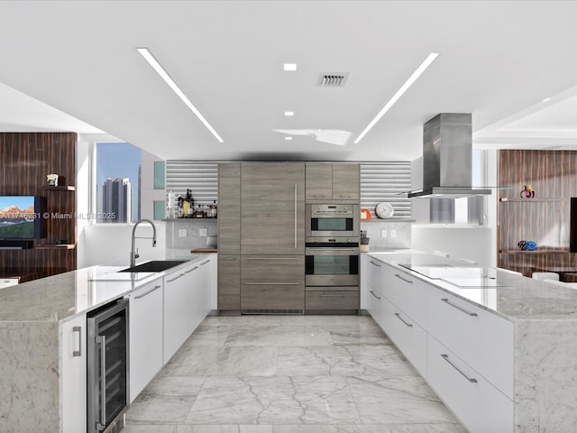 kitchen featuring wine cooler, island exhaust hood, stainless steel double oven, and light stone countertops