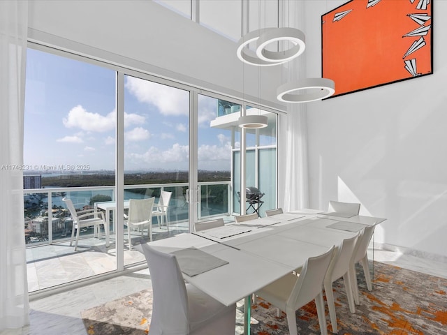 dining area featuring a water view and a high ceiling