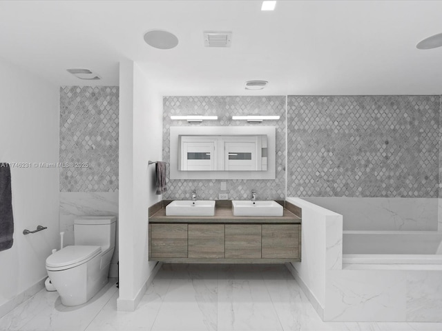 bathroom with vanity, decorative backsplash, and toilet