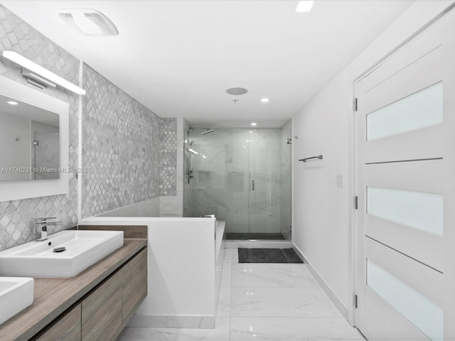 bathroom with vanity, a shower with shower door, and decorative backsplash