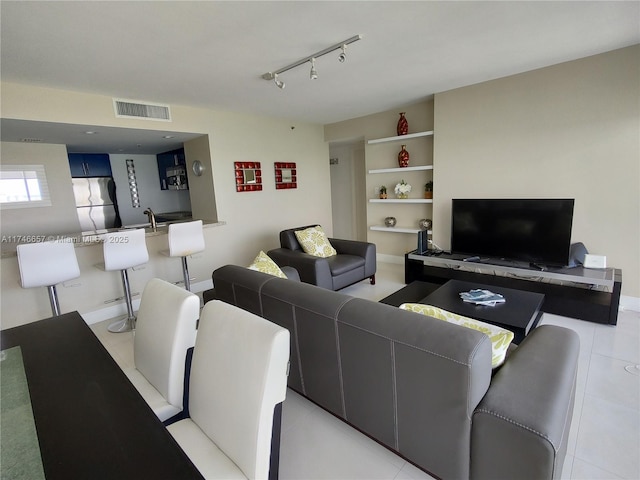 living room featuring light tile patterned flooring and rail lighting