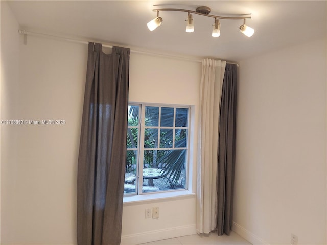 unfurnished room with track lighting