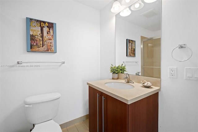 full bathroom featuring tile patterned flooring, a shower with shower door, toilet, vanity, and baseboards