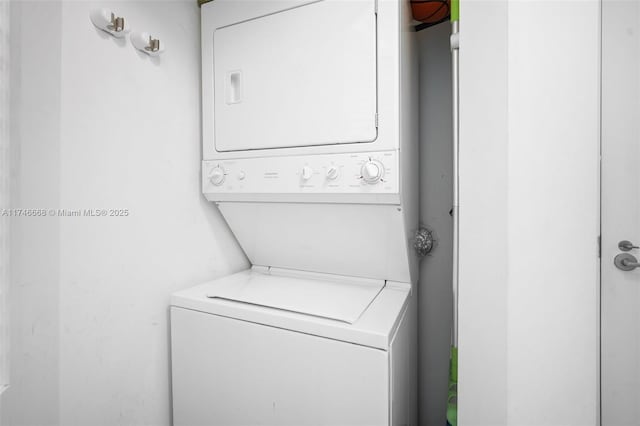 laundry area featuring stacked washer and clothes dryer and laundry area