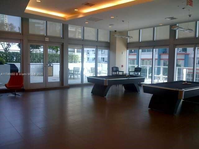 recreation room with plenty of natural light, billiards, and a tray ceiling