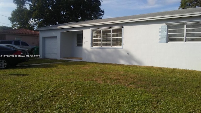 view of front of home featuring a garage and a front lawn