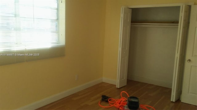 unfurnished bedroom featuring hardwood / wood-style flooring and a closet