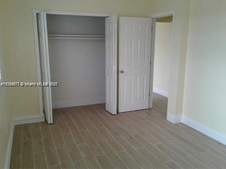 unfurnished bedroom featuring light hardwood / wood-style flooring and a closet