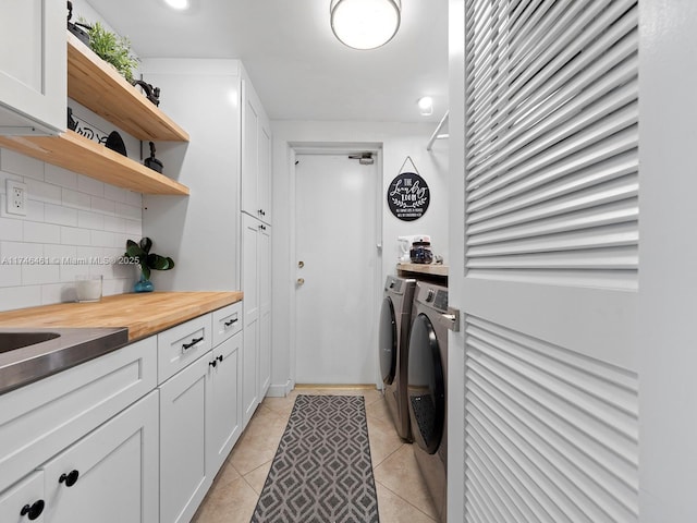 laundry room featuring light tile patterned flooring and separate washer and dryer