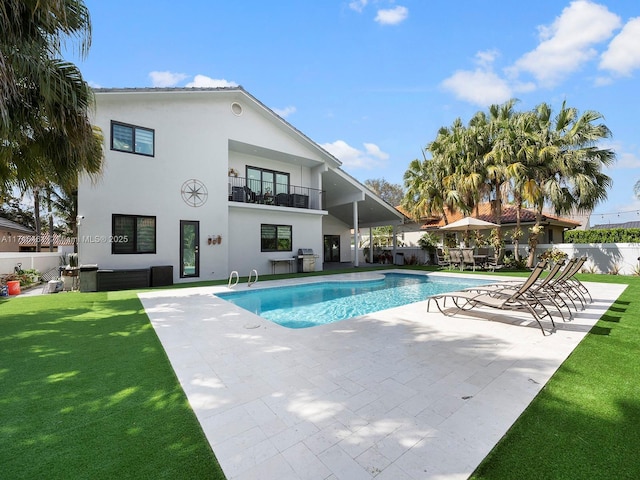 view of pool with a lawn, a patio, and grilling area