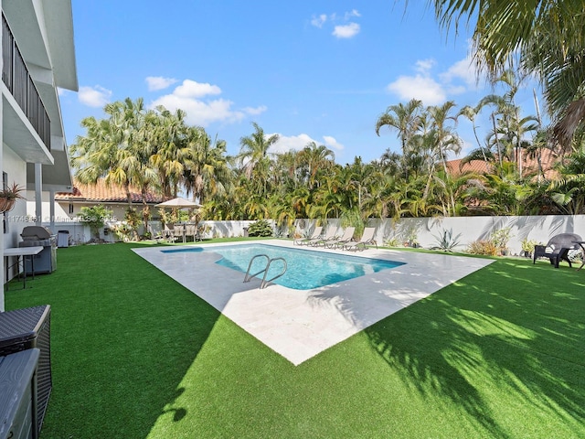 view of pool with a yard and grilling area