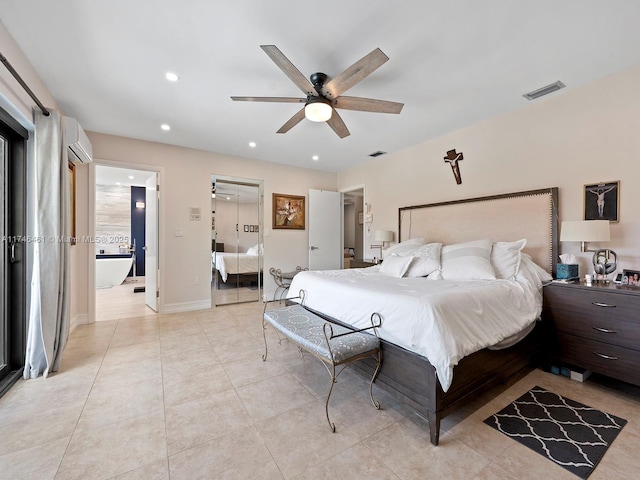 bedroom featuring a wall mounted air conditioner, ensuite bathroom, light tile patterned floors, and ceiling fan