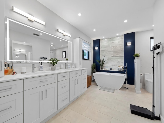 bathroom featuring vanity, toilet, a bathing tub, and tile patterned floors