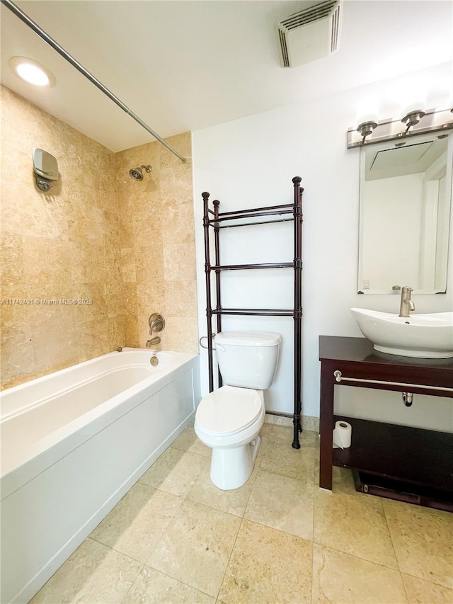 full bathroom featuring tiled shower / bath, vanity, and toilet