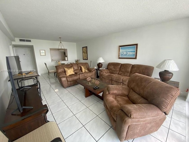 living room with a textured ceiling and light tile patterned floors