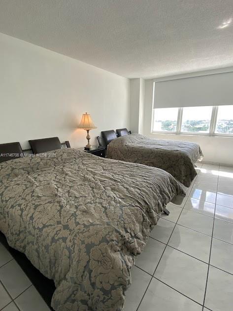 tiled bedroom with a textured ceiling