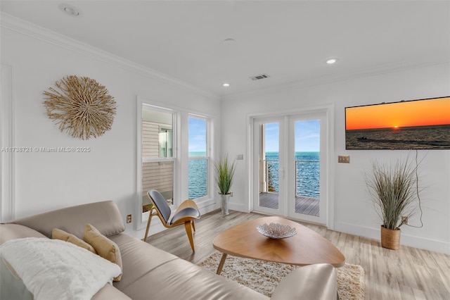 living room with crown molding and light hardwood / wood-style floors