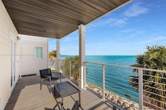 balcony with a water view and a view of the beach