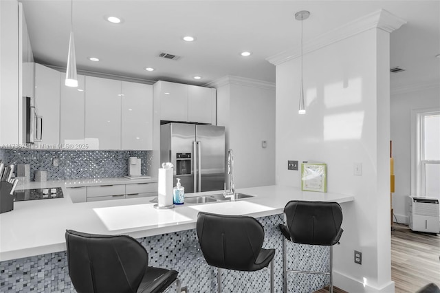 kitchen with pendant lighting, sink, white cabinetry, high end refrigerator, and kitchen peninsula