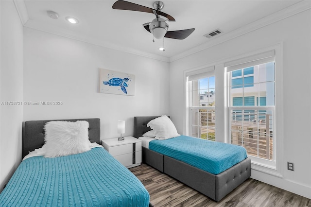 bedroom with hardwood / wood-style flooring, ornamental molding, and ceiling fan