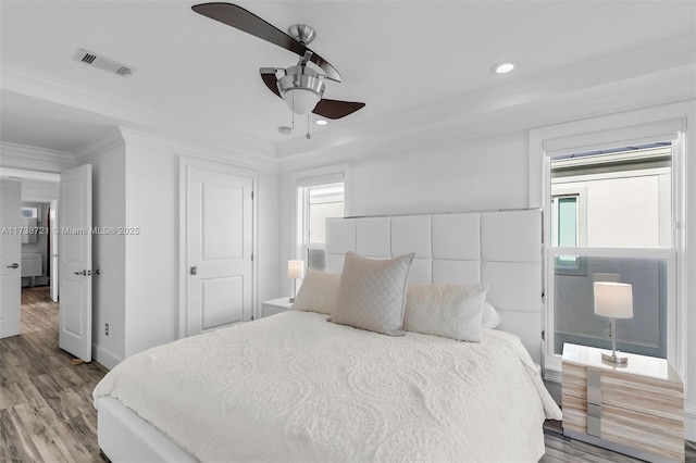 bedroom with crown molding, ceiling fan, and light hardwood / wood-style floors