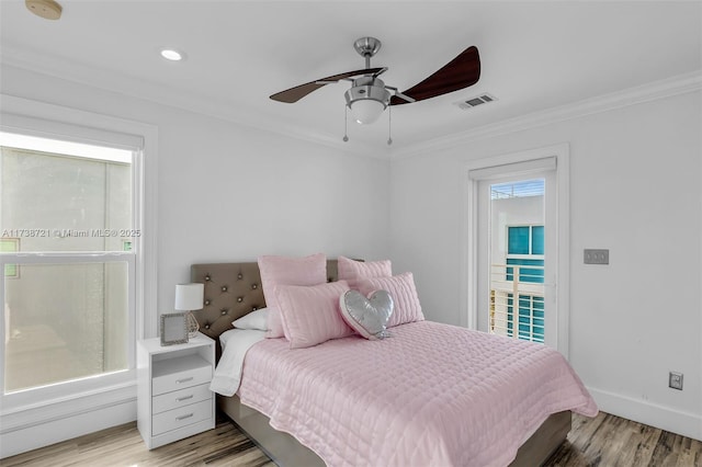 bedroom featuring ornamental molding, light hardwood / wood-style floors, and multiple windows