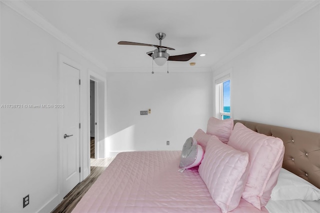 bedroom with hardwood / wood-style flooring, ornamental molding, and ceiling fan