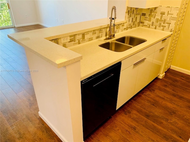 kitchen featuring sink, dark hardwood / wood-style floors, black dishwasher, kitchen peninsula, and backsplash