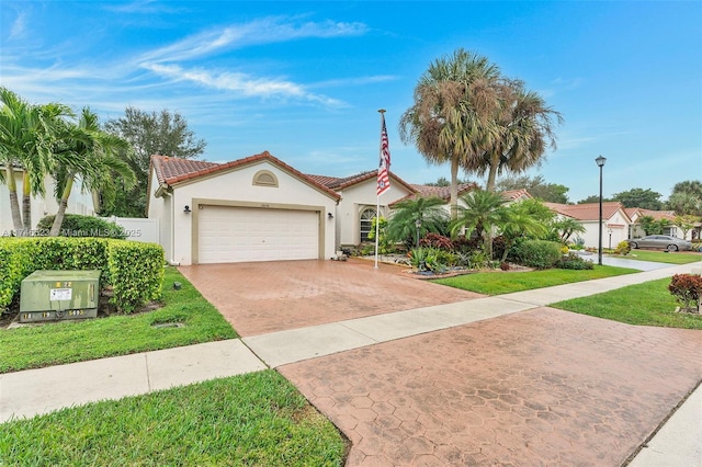 mediterranean / spanish-style home with driveway, a tile roof, an attached garage, and a front yard