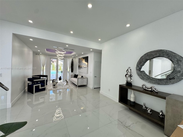 hallway with a raised ceiling and french doors