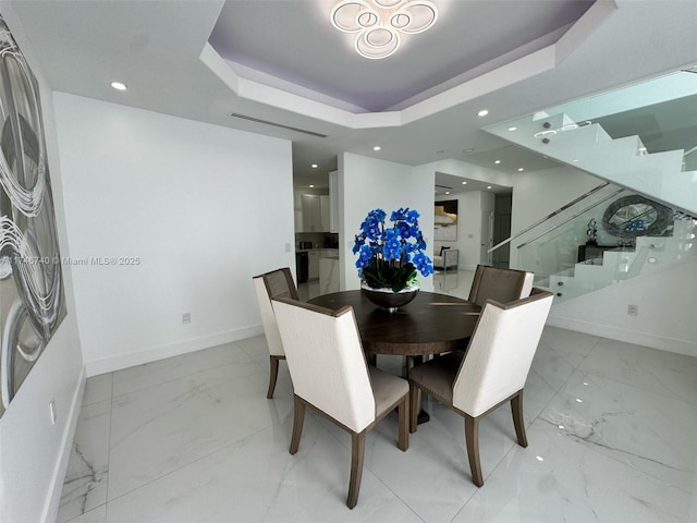 dining area with a raised ceiling