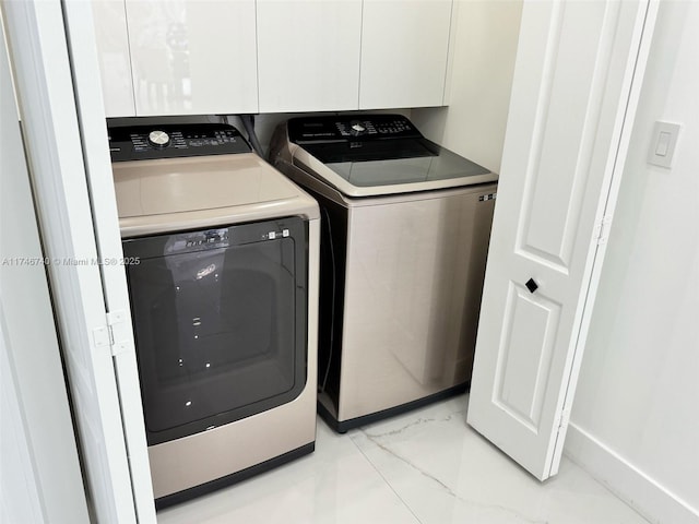 washroom featuring cabinets and washer and dryer