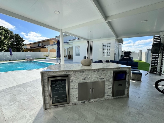 view of patio featuring a bar, pool water feature, and a fenced in pool