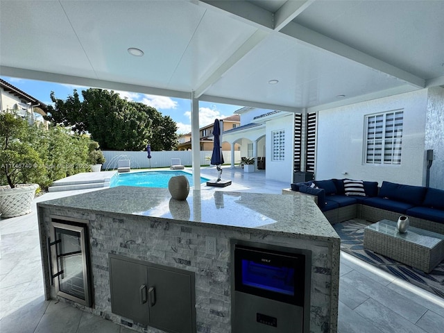 view of patio / terrace featuring a bar, pool water feature, outdoor lounge area, and a fenced in pool