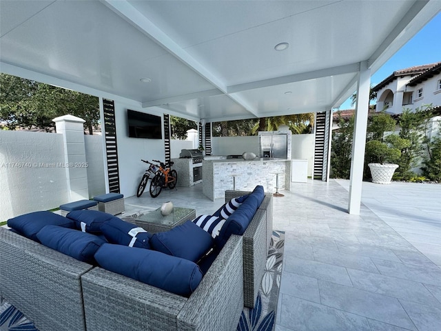 view of patio with area for grilling, an outdoor living space, and an outdoor kitchen