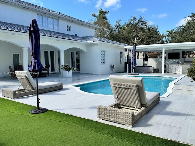 view of pool featuring french doors, a patio, and a jacuzzi