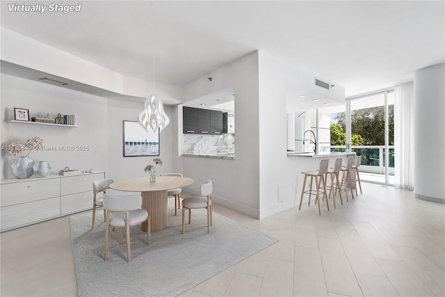 dining room featuring floor to ceiling windows and sink