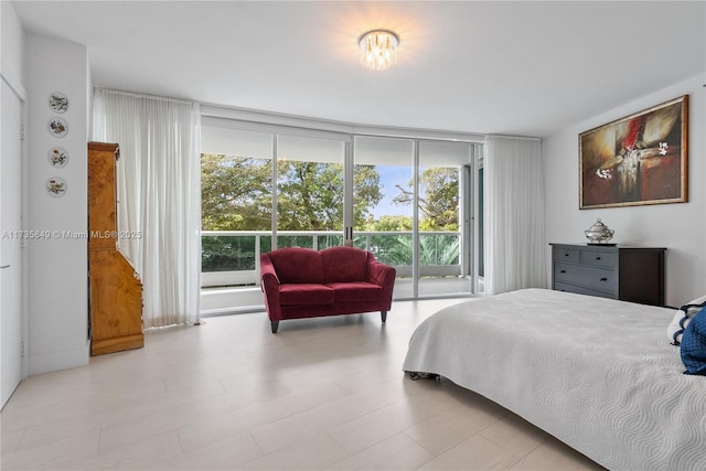 bedroom featuring access to exterior and a wall of windows