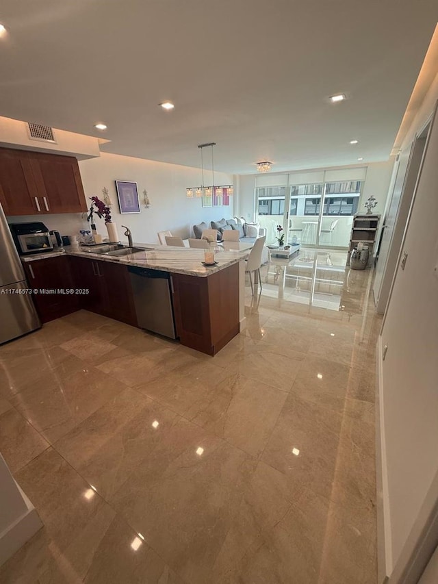 kitchen with light stone countertops, dark brown cabinets, stainless steel appliances, and sink